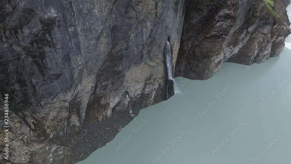 Prise de vue aérienne au drone au dessus d'un barrage. Vue d'un barrage depuis le haut. Petite cascade. Barrage situé à Hérémence en Suisse dans le Valais.