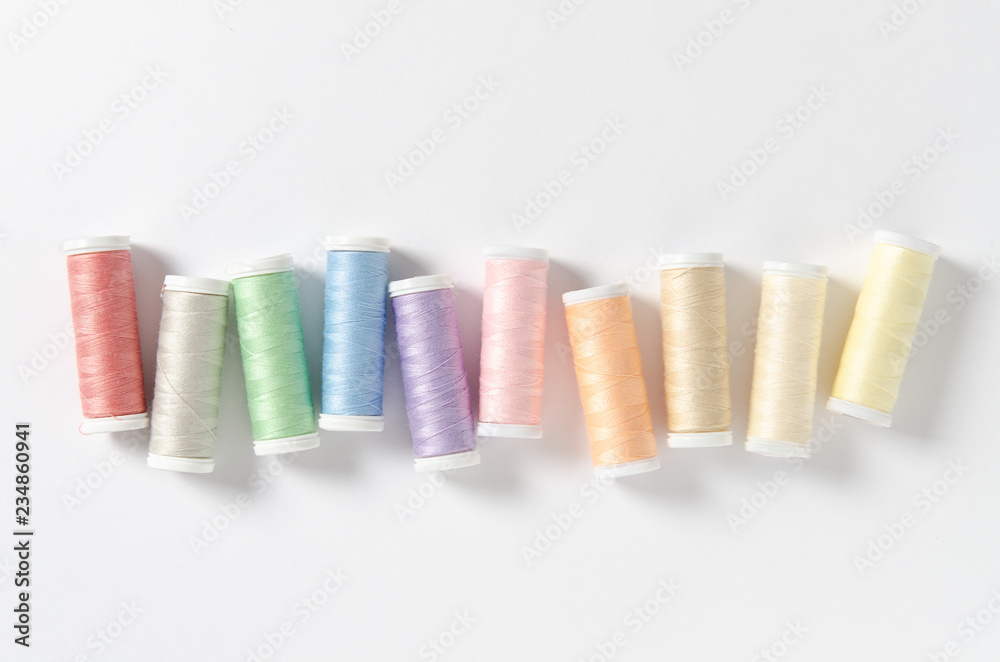 Colored thread coils on white background, sewing. Top view Colored thread coils on white background, sewing. Top view
