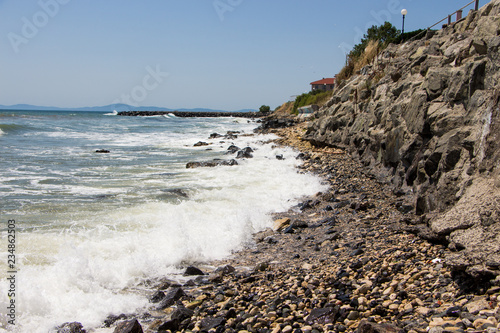 Landscape of the sea and sea coast with rocks and blue sky. Sea waves crashing on the rocks. Black sea. Ravda. Bulgaria. photo