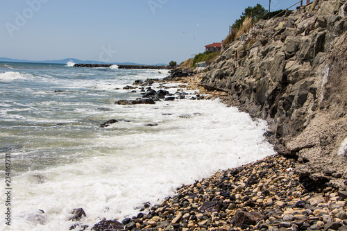 Landscape of the sea and sea coast with rocks and blue sky. Sea waves crashing on the rocks. Black sea. Ravda. Bulgaria. photo