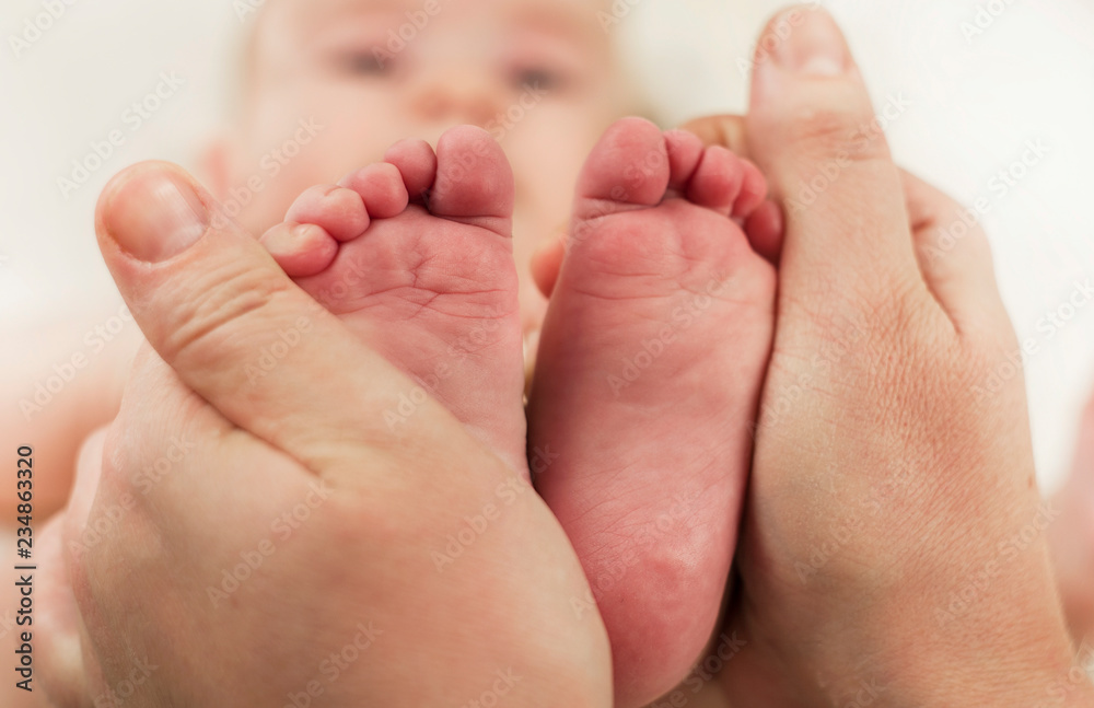 Parent holds gentle little feet in a newborn baby Parent holds gentle little feet in a newborn baby