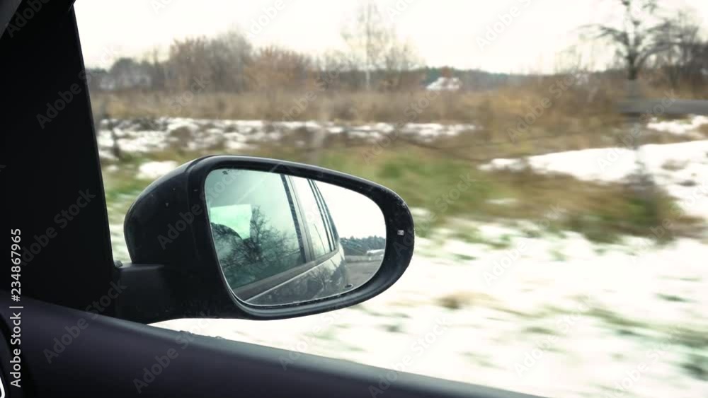 View of the road in the rearview mirror of a car at winter, Village ride View of the road in the rearview mirror of a car at winter, Village ride