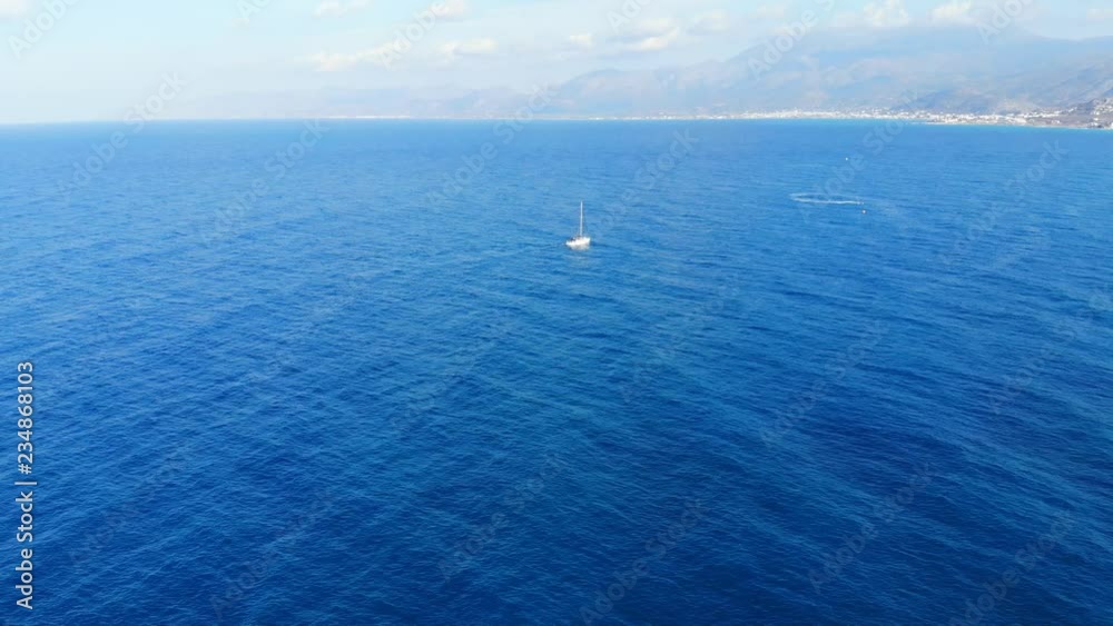 Aerial panorama on blue sea and small white yacht sailing away, Crete, Greece Aerial panorama on blue sea and small white yacht sailing away, Crete, Greece