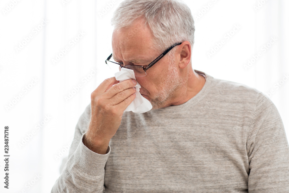 healthcare, flu, hygiene and people concept - sick senior man with paper wipe blowing his nose at home healthcare, flu, hygiene and people concept - sick senior man with paper wipe blowing his nose at home