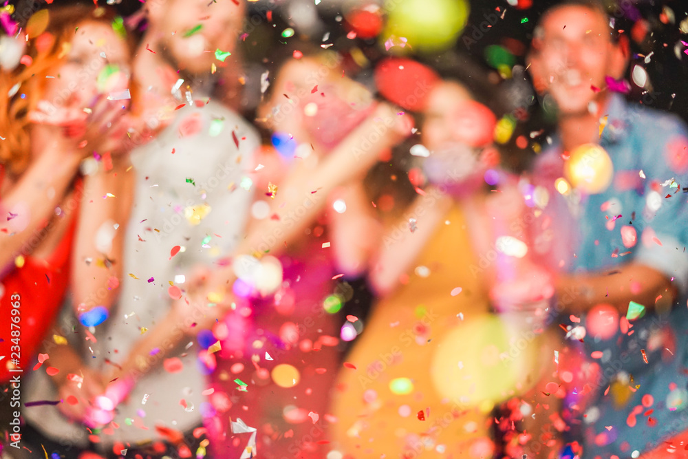 Blurred people making party throwing confetti - Young people celebrating on weekend night - Entertainment, fun, new year's eve, nightlife and fest concept - Defocused photo - obrazy, fototapety, plakaty 