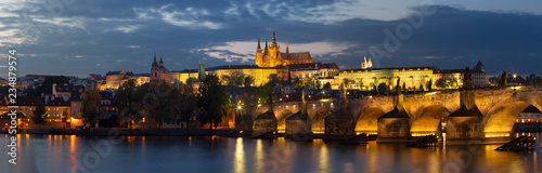 Prague - The Charles Bridge, Castle and Cathedral from promenade over the  Vltava river at dusk.