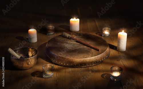 Tableau sur toile Shaman tambourine and Tibetan bowl surrounded by candles in a dark room