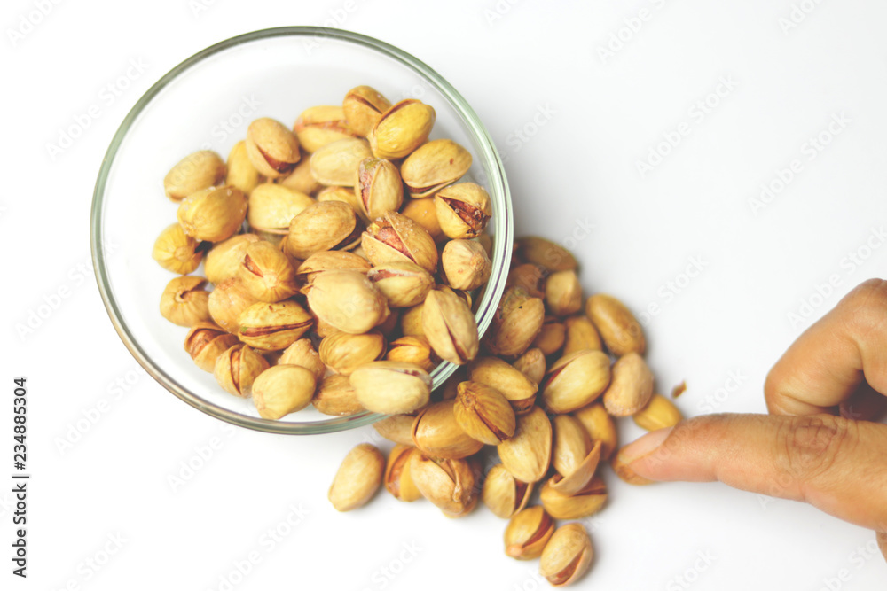 glass of wine filled with salty pistachio nuts on a table glass of wine filled with salty pistachio nuts on a table