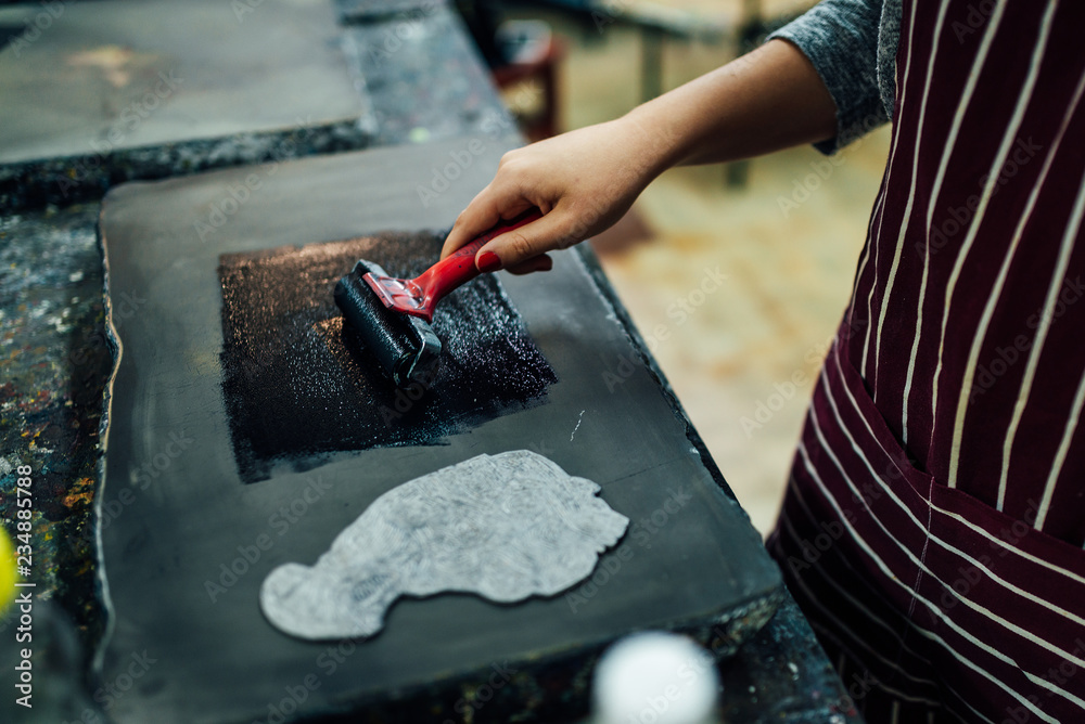 linocut. rolling paint on a piece of linoleum Stock Photo Adobe Stock