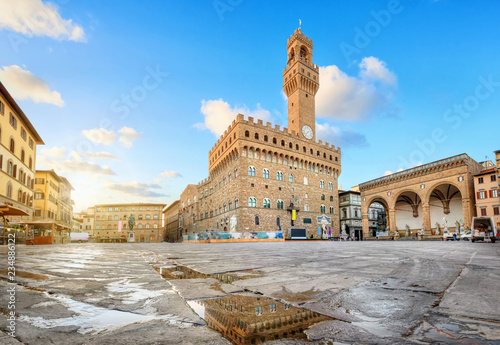 Florence, Italy. View of Piazza della Signoria square with Palazzo Vecchio reflecting in a puddle at sunrise photo