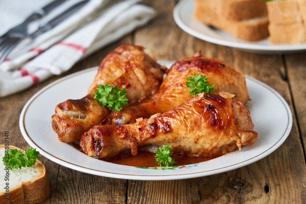 Chicken legs with tomato sauce and spices on a plate Chicken legs with tomato sauce and spices on a plate