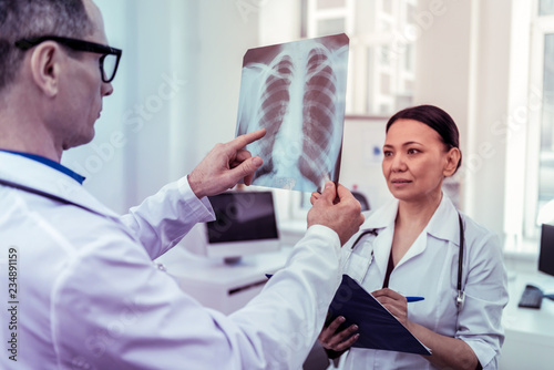 Concentrated international doctor working with her partner photo