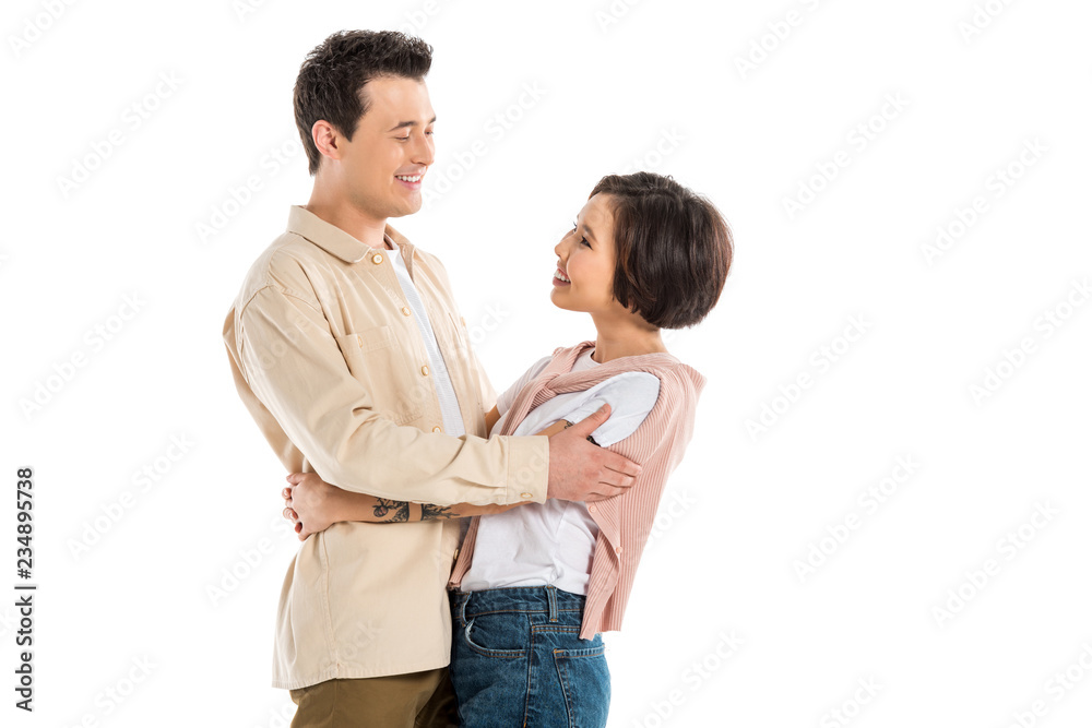smiling husband and beautiful wife in casual clothes hugging and looking at each other isolated on white smiling husband and beautiful wife in casual clothes hugging and looking at each other isolated on white