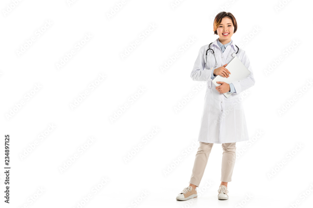 smiling female doctor looking at camera, standing and holding diagnosis isolated on white smiling female doctor looking at camera, standing and holding diagnosis isolated on white