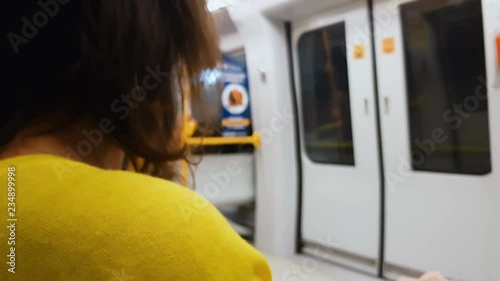 Woman in yellow blouse getting home train, monotony lifestyle, public transport