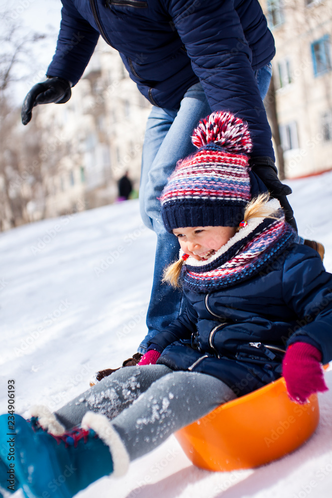 Little girl sliding sown the hill on sledge with snow around Little girl sliding sown the hill on sledge with snow around