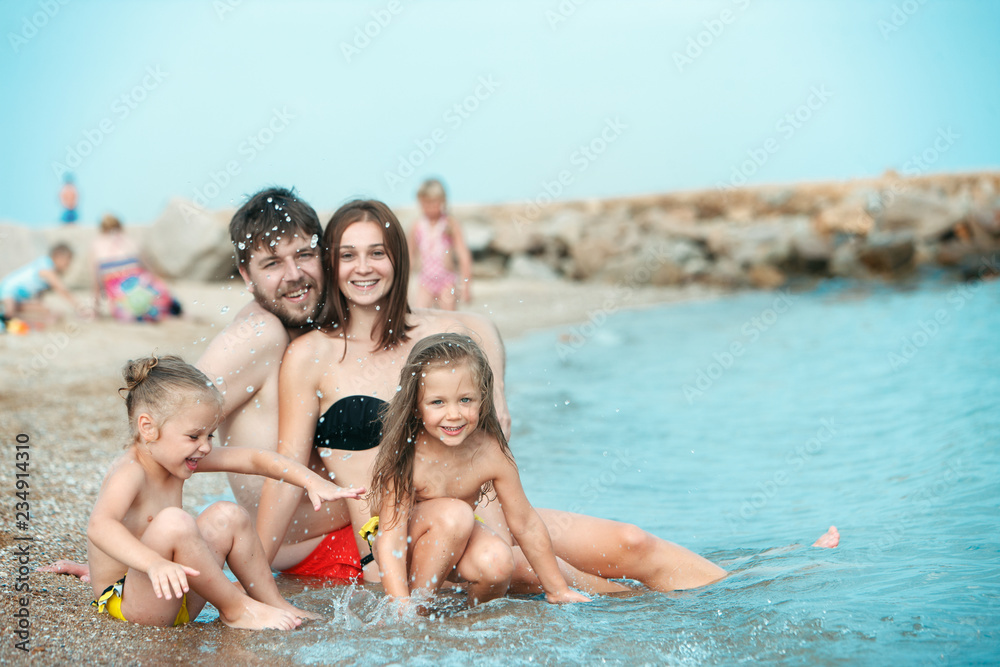 Happy family enjoying walk on the sea beach. The summer, childhood, holiday, leisure, lifestyle, travel, vacation concept Happy family enjoying walk on the sea beach. The summer, childhood, holiday, leisure, lifestyle, travel, vacation concept