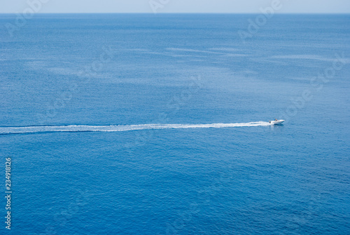 Single white motor boat with long trail behind