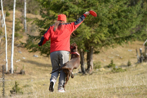 Young woman playing with her German Shorthaired Pointer
