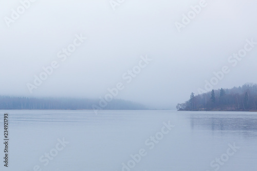 Beautiful landscape of arctic lake in the forest. Blue fog on the water © alexander132