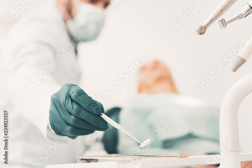 Close up of doctors hand with dental reflector