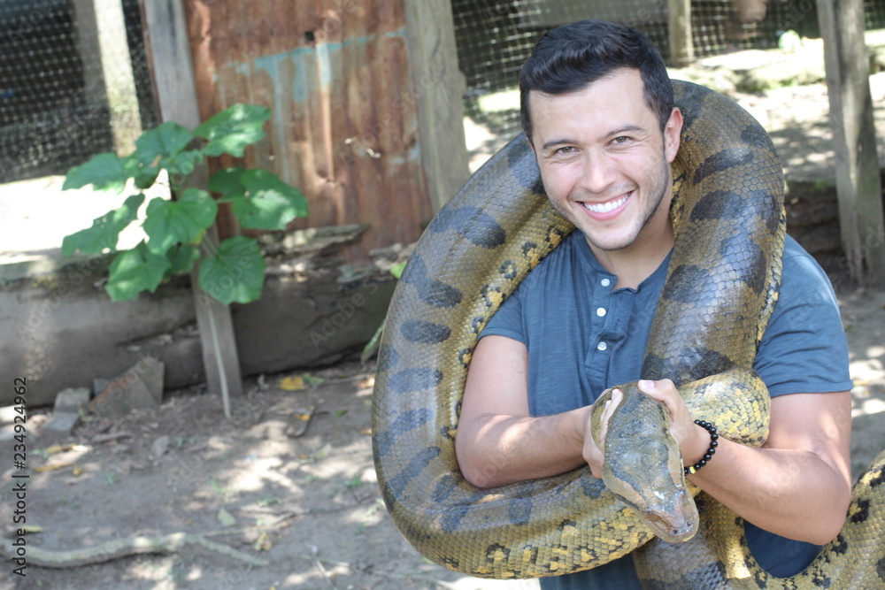 Naklejka premium Man showing affection for a gigantic snake
