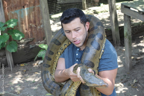 Powerful man struggling with gigantic anaconda