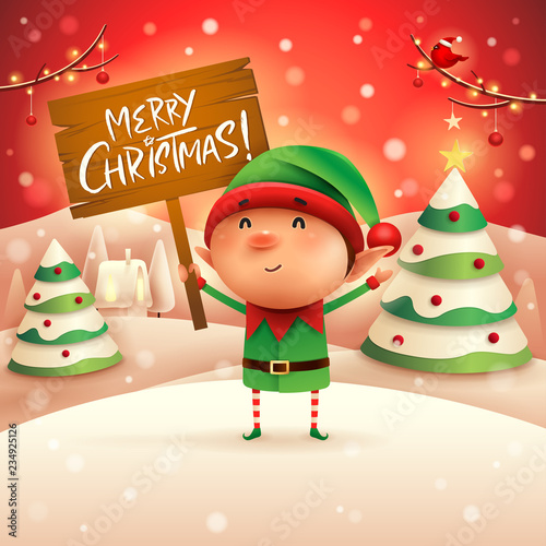 Merry Christmas! Cheerful snowman holds wooden board sign in Christmas snow scene winter landscape.