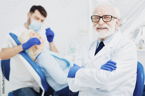 Merry male dentist teaching intern