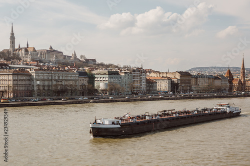 Photography Sailing cargo ship on Danube river with Budapest landmark - Fisherman's Bastion