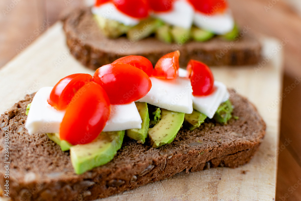 Slice of bread with avocado and tomato.