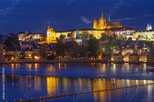Prague - The Charles Bridge  Castle and Cathedral from promenade over the  Vltava river at dusk.