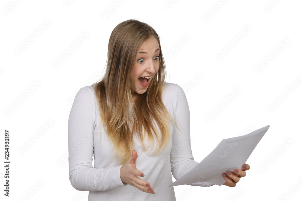 Junge blonde Frau schaut begeistert auf einen Brief in ihrer Hand Junge blonde Frau schaut begeistert auf einen Brief in ihrer Hand