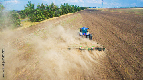 A tractor plowing and sowing in the field