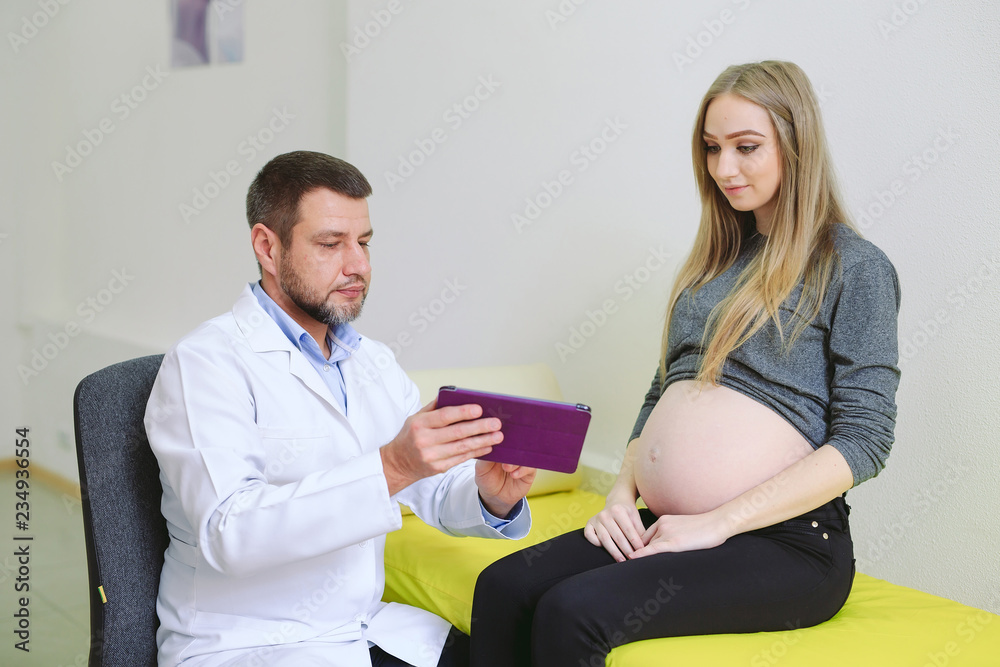 Gynecologist showing echo photo to pregnant woman. Gynecologist showing echo photo to pregnant woman.