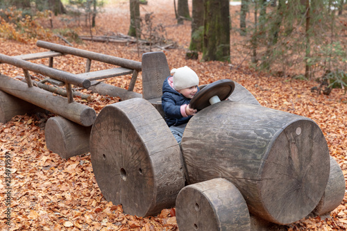 Babygirl riding a wooden toy truck photo