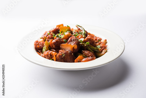 Indian Chilli Chicken dry, served in a plate over moody background. Selective focus