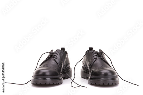 Untied shoelaces in black shoes. A pair of boots on a white background.