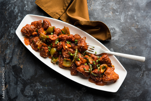 Принти на полотні Indian Chilli Chicken dry, served in a plate over moody background