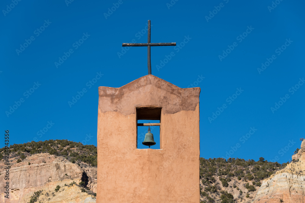 Bell tower and rustic wood cross of the Abbey Church under a perfect blue sky at the Monastery of Christ in the Desert near Abiquiu, New Mexico Bell tower and rustic wood cross of the Abbey Church under a perfect blue sky at the Monastery of Christ in the Desert near Abiquiu, New Mexico