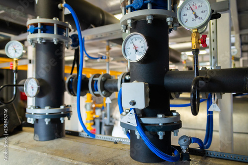 The equipment of the boiler-house, valves, tubes, pressure gauges, thermometer. Close up of manometer, pipe, flow meter, water pumps and valves of heating system in a boiler room