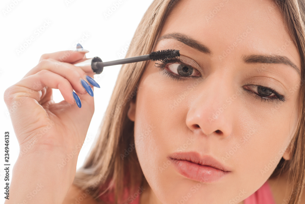 Beautiful young woman applying make up with a brush on white background Beautiful young woman applying make up with a brush on white background