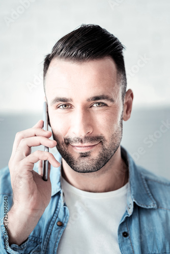 Delighted young man talking per telephone