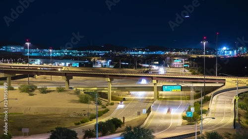 Phoenix AZ Night Timelapse Over Highway 202 East to Tempe and Mesa with Streaking Lights from Driving Vehicles and Arriving Jet Airliners in a Blue Evening Sky photo