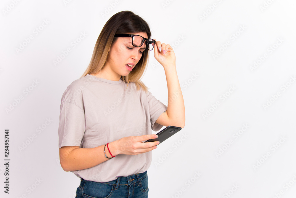 Girl on white with cell phone smiling using  internet social media concept 