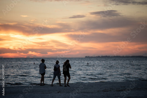 silhouettes of people after sunset at the beach