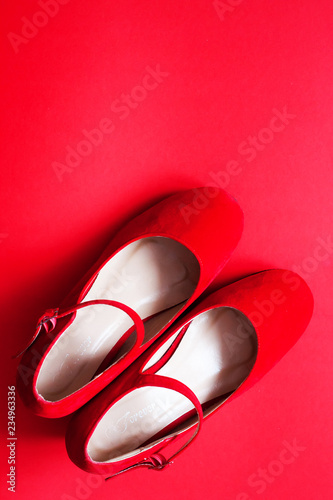Red woman shoes on red background. Feminine fashion concept background.