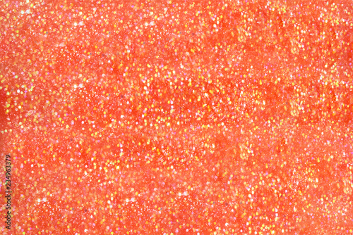 Orange nail polish with golden glitter background. High resolution close up photo.