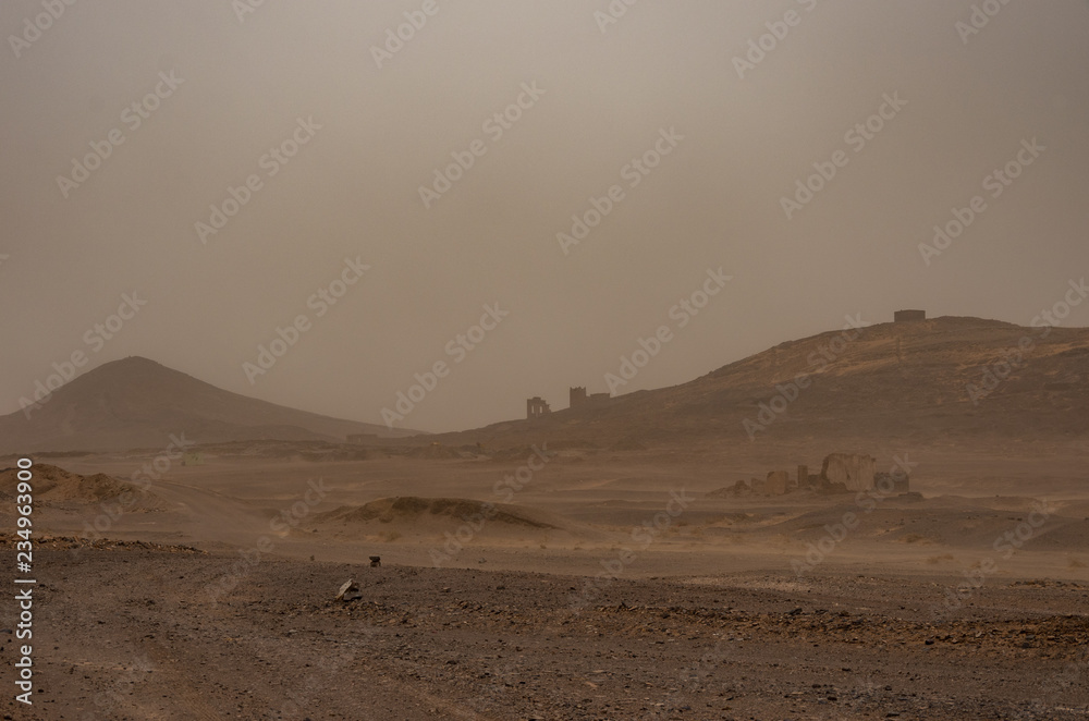 Ruined village near sahara Erg Chebbi dune in sand storm. Morocco Ruined village near sahara Erg Chebbi dune in sand storm. Morocco