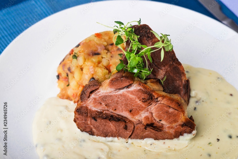 Baked pork,mashed potato, green thyme and pepper sauce, closeup. Baked pork,mashed potato, green thyme and pepper sauce, closeup.